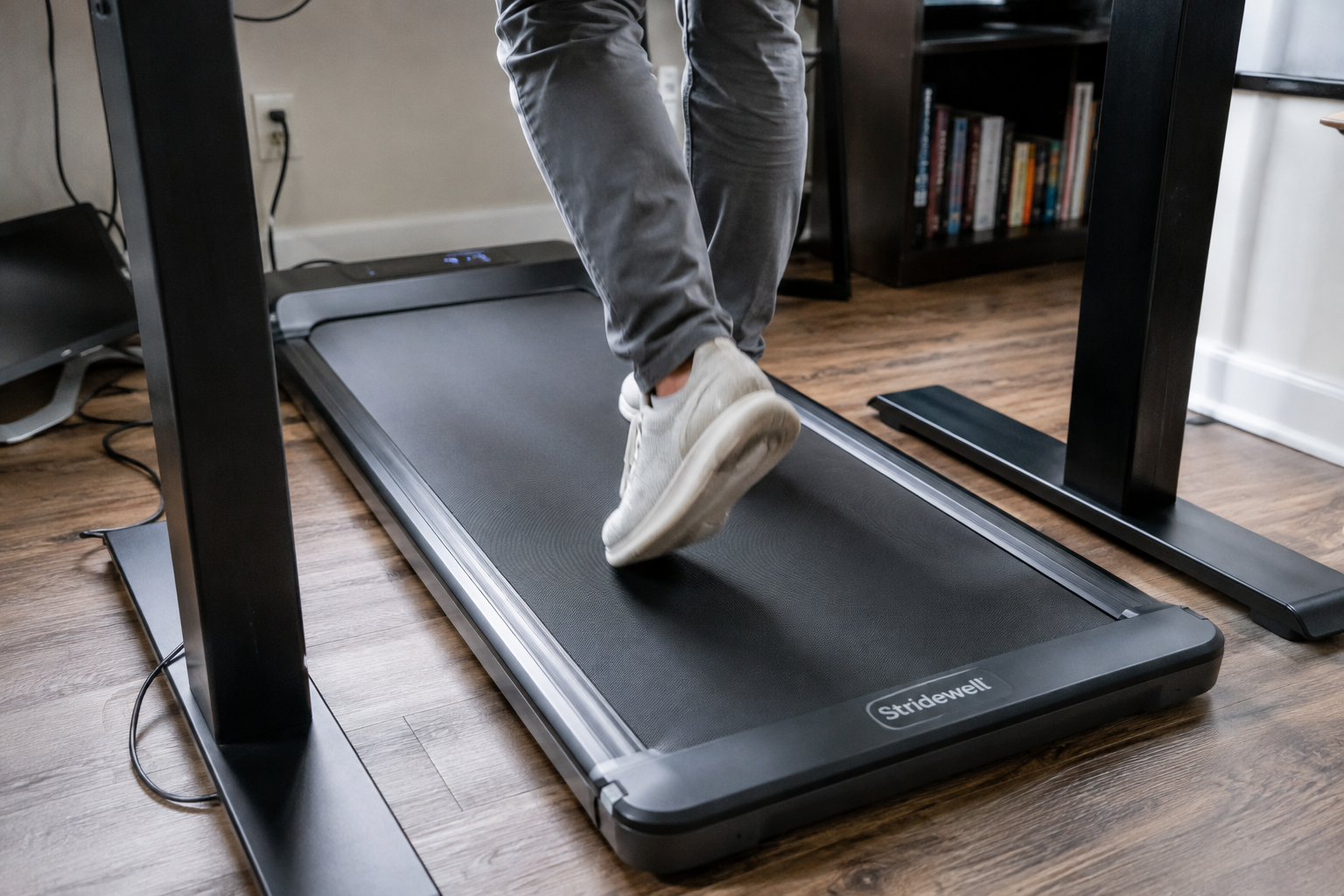 Close-up of sneakers walking on an under-desk walking pad belt