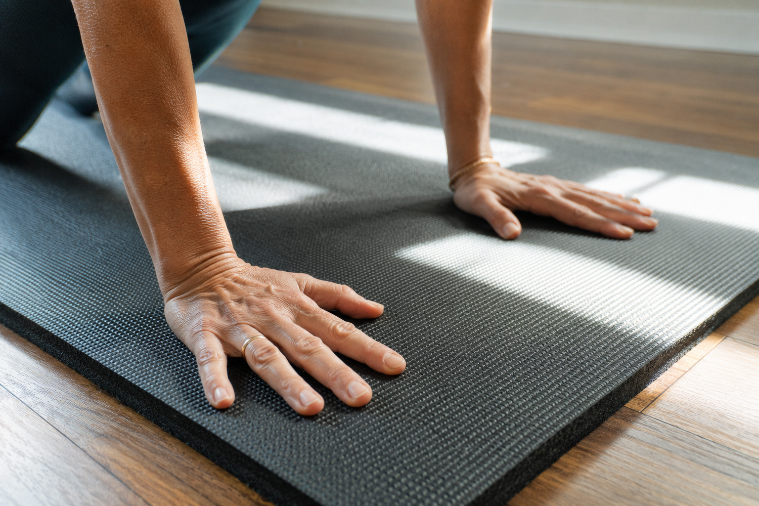 Hands pressed into the textured non-slip surface of a thick exercise mat